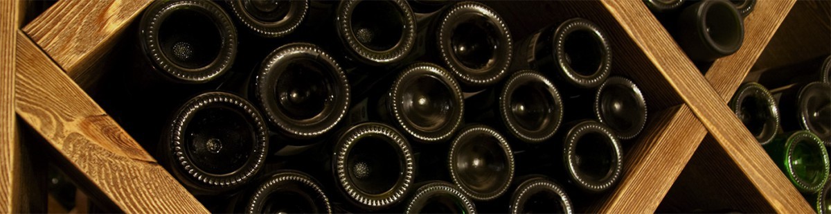 Bouteilles de vin couchées dans un casier de cave en bois à alvéoles en losange