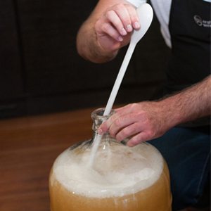 Chris degassing a carboy with a long spoon