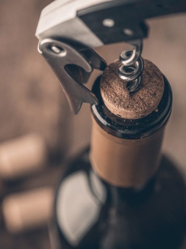 Corkscrew and bottle of wine on the board