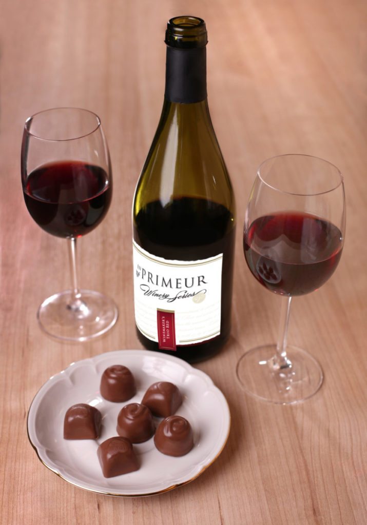 two glasses of red wine chocolate and bottle